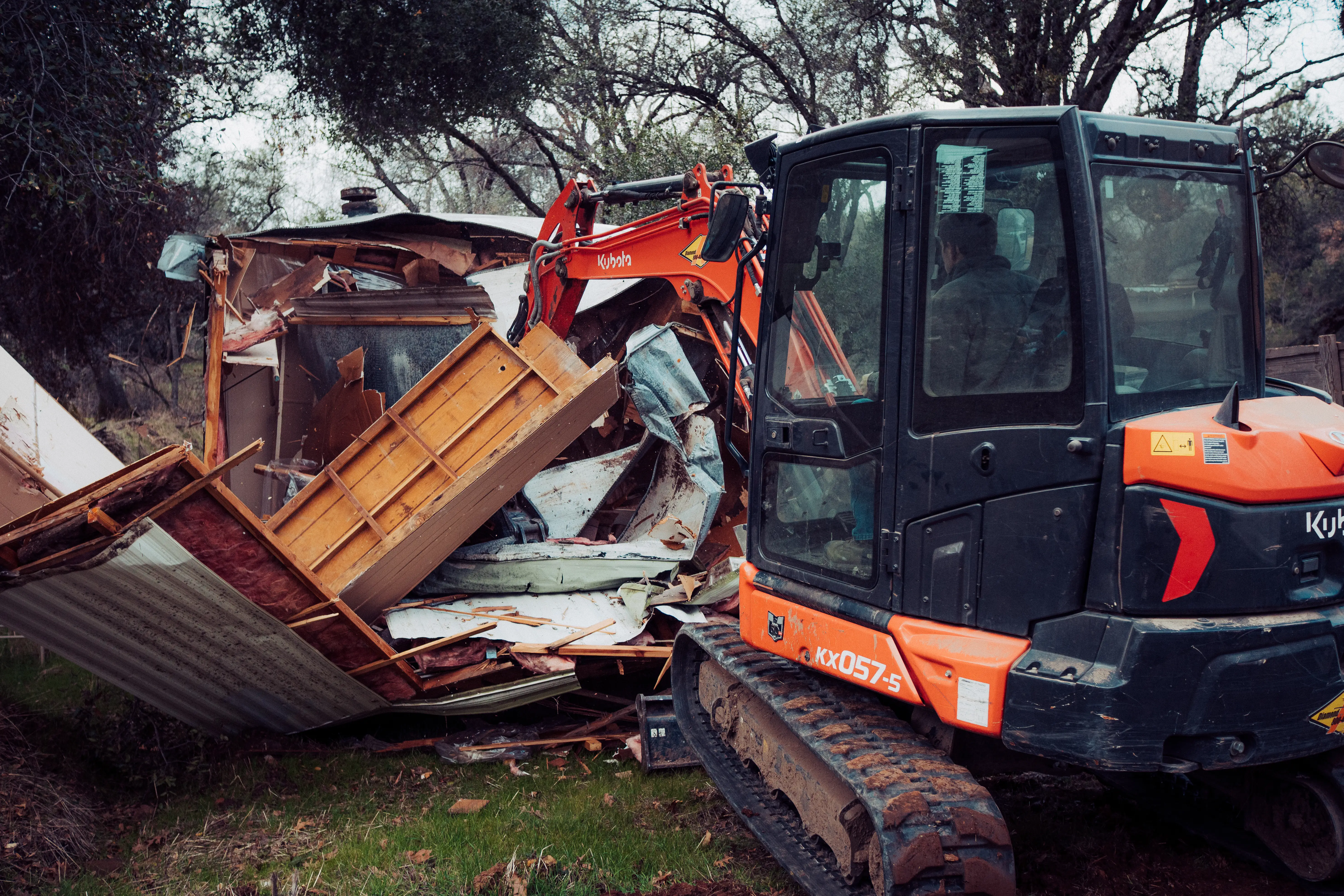 Kubota excavator working through a mobile home teardown