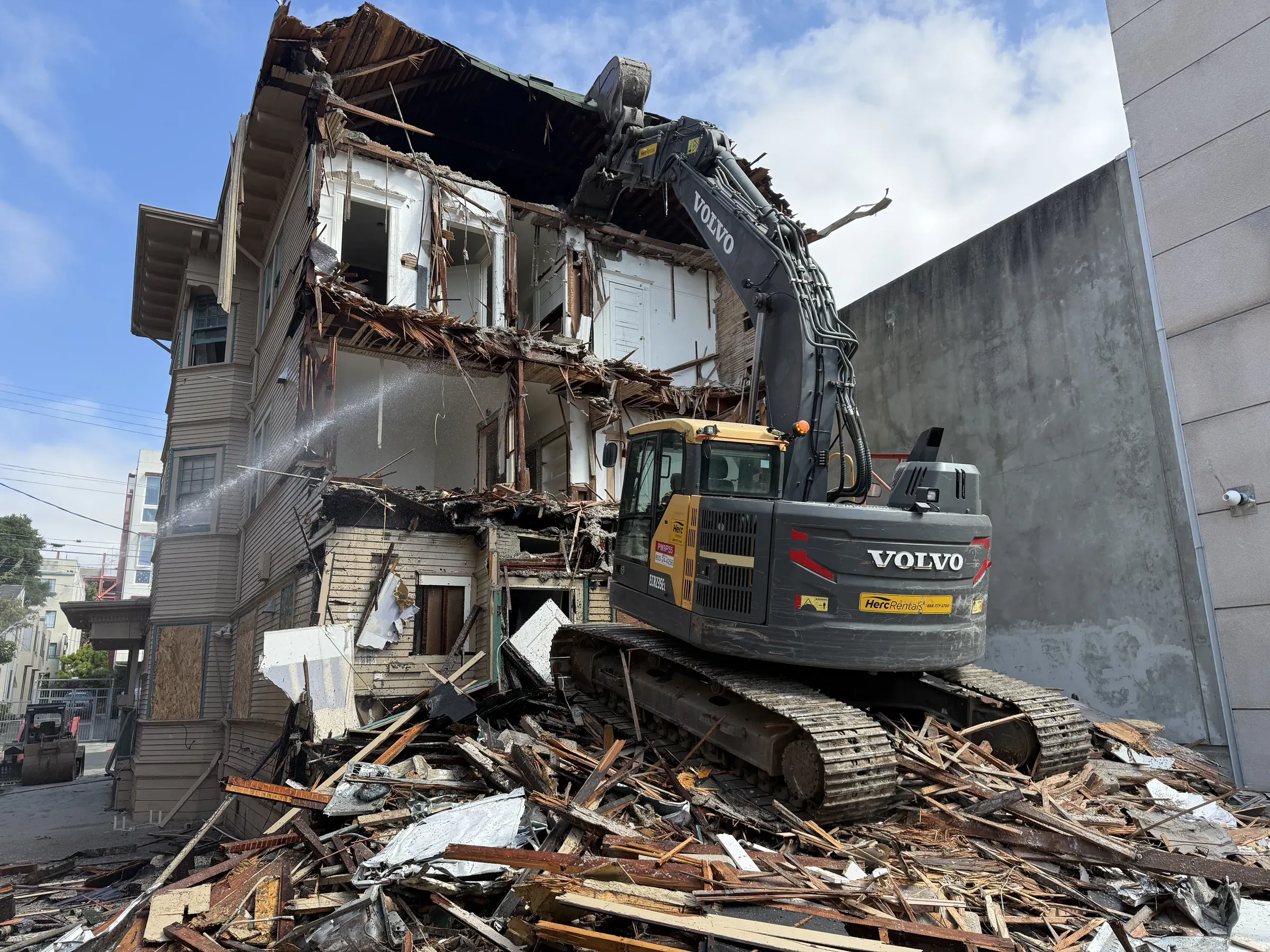 Demo Patrol excavator demolishing a multi-story house in Northern California with debris haul-off underway